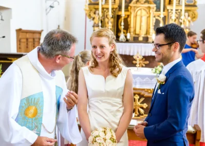 Brautpaar bei kirchlicher Trauung in St. Benedikt Gelting, Hochzeitsfoto zeigt Freude und Emotion während der Zeremonie.
