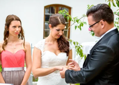 Freie Trauung: Paar tauscht Ringe aus im Garten von Schloss Sulzemoos. Hochzeitsreportage von Hochzeitsfotograf.