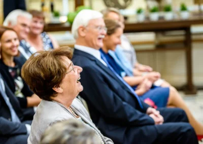 Gäste lachen bei der freien Trauung im Gasthof Stangl. Hochzeitsreportage in Neufarn bei München.