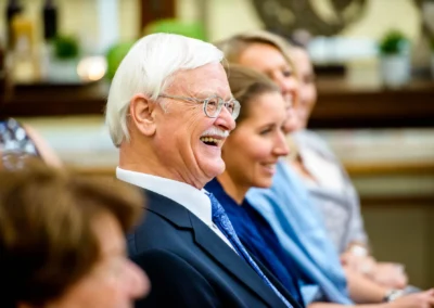 Lachender Gast bei freier Trauung im Gasthof Stangl. Hochzeitsfotografie in Neufarn bei Muenchen.