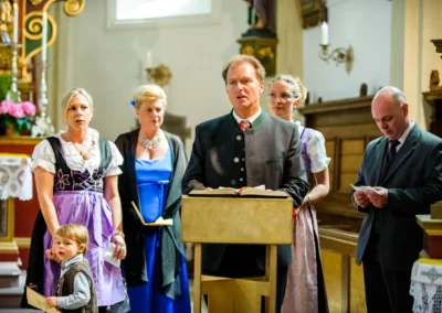 Kirchliche Trauung in Bayern mit Gästen in traditioneller Kleidung bei einer Hochzeitsreportage in der Frauenkirche Osterwarngau.