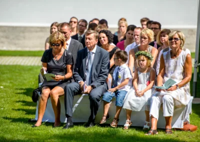 Gaste sitzen entspannt bei einer freien Trauung im Brucker Land, festgehalten von einem Hochzeitsfotografen.