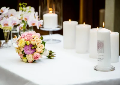 Blumenstrauss und Kerzen bei Trauung im Gutsgasthof Stangl, Hochzeitsfotografie in Neufarn bei Muenchen.