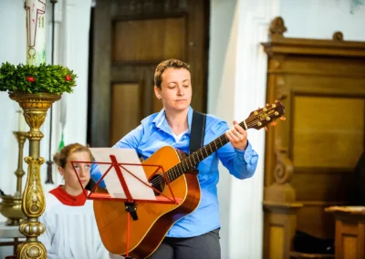 Musiker spielt Gitarre bei kirchlicher Trauung in der Frauenkirche Osterwarngau, festgehalten von einem Hochzeitsfotografen.