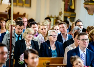 Gäste sitzen in der Dorfkirche Moosach während einer kirchlichen Trauung, festgehalten in einer Hochzeitsreportage.