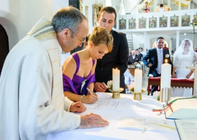 Hochzeitsreportage in Ottendichl bei kirchlicher Trauung, Brautpaar und Priester im Vordergrund.