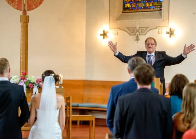 Kirchliche Trauung in Miesbach, Brautpaar vor Altar, Hochzeitsfotografie in der neuapostolischen Kirche.