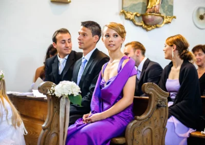 Gäste bei kirchlicher Trauung in Ottendichl, elegant gekleidet, Hochzeitsreportage zeigt Bänke und Blumenschmuck.