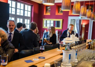Hochzeitsfoto einer Feier in Bad Toelz. Menschen unterhalten sich an einer stilvollen Bar bei einer Hochzeitsreportage.