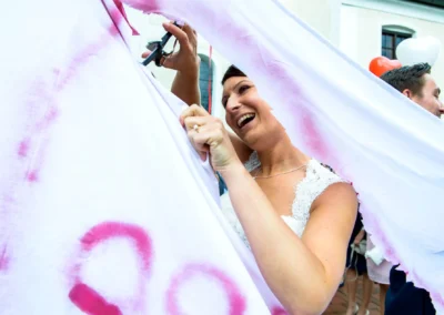 Braut schneidet ein Tuch bei einer Hochzeit in Moosach bei Grafing, festgehalten in einer Hochzeitsfotoreportage.