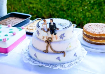 Hochzeitstorte mit Brautpaar-Figur auf Tisch bei Hochzeit im Gasthof zur Post, festlich dekoriert.