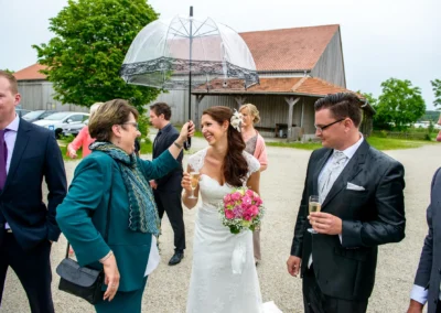 Brautpaar und Gaeste bei Hochzeit im Gut Schloss Sulzemoos, Hochzeitsfotografie in heiterer Atmosphaere.
