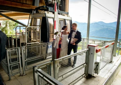 Brautpaar verlässt Gondelbahn am Schliersberg-Alm vor Alpenkulisse. Aufnahme bei einer Hochzeit in Oberbayern.