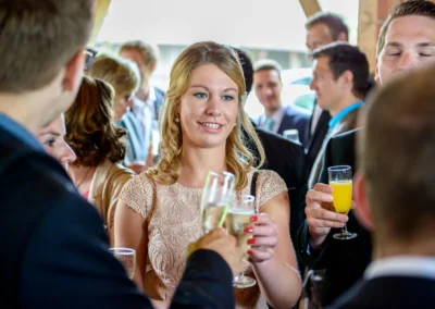 Gäste stoßen bei einer Hochzeit auf Gut Schloss Sulzemoos an, festgehalten in einer Hochzeitsreportage.