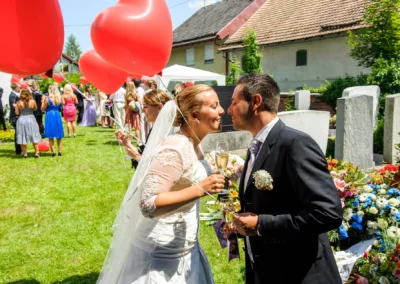 Brautpaar mit roten Luftballons feiert romantische Hochzeit in Taufkirchen bei Muenchen, Hochzeitsreportage.