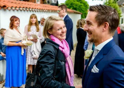 Hochzeitsfoto zeigt lachende Gaeste bei einer Hochzeit in Moosach bei Grafing. Hochzeitsreportage in Oberbayern.