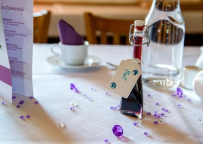 Hochzeitsfoto mit Tischdeko und personalisierter Flasche bei einer Hochzeit in einem Gasthof nahe München.