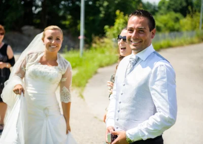 Brautpaar bei sonniger Hochzeit in Neukeferloh. Hochzeitsfoto zeigt froehlichen Moment im Freien.