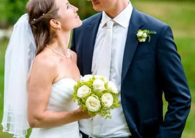 Brautpaar bei einer Hochzeit auf Gut Georgenberg, Braut mit Blumenstrauss und Braeutigam im Anzug, Hochzeitsfoto.