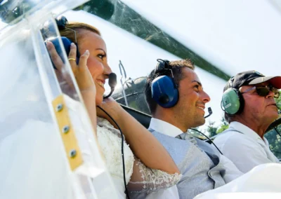 Brautpaar fliegt mit Pilot bei Hochzeit in Neukeferloh, Hochzeitsfoto zeigt Freude und Abenteuerlust.