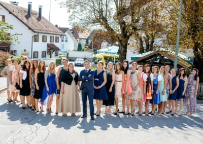 Hochzeitsgesellschaft vor Gasthof Widmann versammelt, sonniger Tag in Oberbayern, Hochzeitsreportage nahe München.