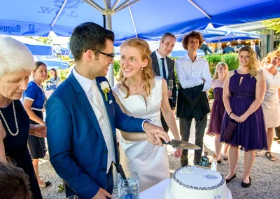 Brautpaar schneidet Hochzeitstorte im Gasthof zur Post nahe Starnberger See. Hochzeitsfotograf fängt den Moment ein.