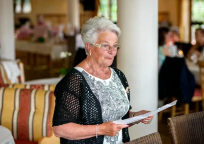 Ältere Frau haelt eine Rede bei Hochzeit in einem Raum in Altwirt. Hochzeitsfotograf aus Oberbayern.
