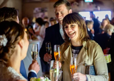Gäste stoßen bei einer Hochzeit in Moosach bei Grafing an, festgehalten in einer lebhaften Hochzeitsfotografie.