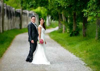 Brautpaarshooting auf einem Waldweg bei Schloss Sulzemoos, elegante Hochzeitsfotografie im Freien.