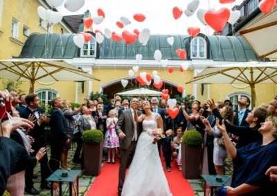 Brautpaar mit Familie und Freunden laesst Ballons bei Hochzeit im Gasthof Stangl in Neufarn bei Muenchen steigen.