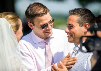 Bräutigam lacht mit Freunden bei Hochzeit in der Alten Gaertnerei Taufkirchen. Hochzeitsfoto in entspannter Atmosphäre.