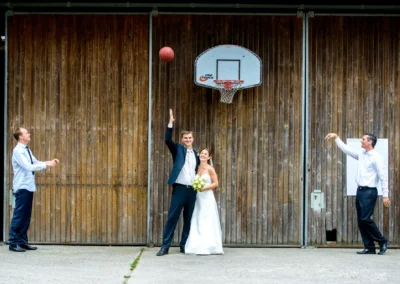 Brautpaar posiert beim Basketballspiel, Hochzeitsfotografie in Gut Georgenberg, kreative Hochzeitsportraits.