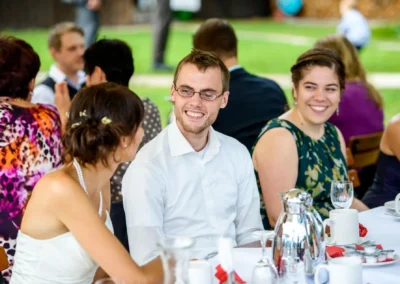 Gaste bei einer Hochzeit im Kreis Miesbach, lachend und im Gesprach; Hochzeitsfotografie momentaufnahme.