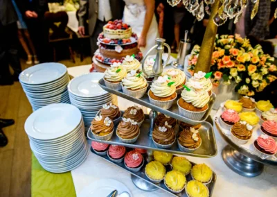 Hochzeitsfoto: Cupcakes und Hochzeitstorte bei Feier im Gasthof Stangl, begleitet von Blumenarrangement.