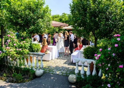 Gartenhochzeit in der Alten Gaertnerei Taufkirchen mit Gaesten und Brautpaar bei sonnigem Wetter. Hochzeitsfotograf.