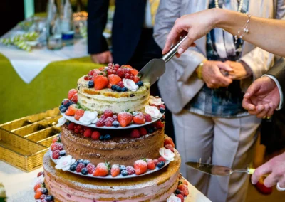 Hochzeitstorte wird bei einer Hochzeitsfeier im Gasthof Stangl in Neufarn bei Muenchen angeschnitten. Hochzeitsfoto.