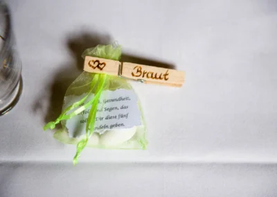 Kleine Gastschenke mit Holzklammer Braut bei einer Hochzeit in Moosach bei Grafing, festlich dekoriert.