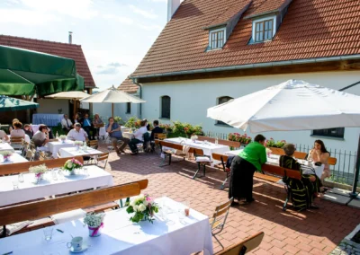Gedeckte Hochzeitstische draussen bei Gut Schloss Sulzemoos, Gaeste unter Sonnenschirmen. Hochzeitsfotografie im Freien.