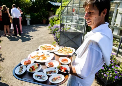 Kellner mit Tablett voller Vorspeisen bei einer Hochzeit in der Alten Gaertnerei Taufkirchen.