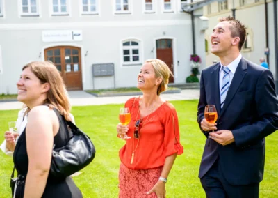 Gäste lachen bei einer Hochzeit im Kloster Fürstenfeld, fotografiert von einem Münchner Hochzeitsfotografen.