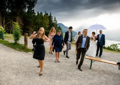Hochzeitsgaeste gehen den Pfad entlang in Schliersberg-Alm, Hochzeit in malerischer Umgebung fotografiert.