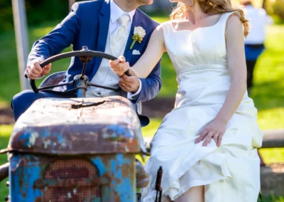Ein Brautpaar auf einem Traktor bei einer Hochzeit im Gasthof zur Post in Aufkirchen, festgehalten von einem Hochzeitsfotografen.