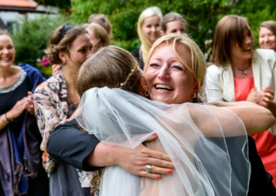 Umarmung zweier Frauen bei einer Hochzeit in Gut Georgenberg, festgehalten als Hochzeitsfotografie voller Freude.
