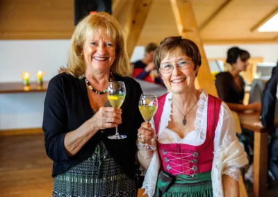 Zwei Frauen heben Glaeser zur Hochzeit im Moarwirt Hechenberg. Hochzeitsfoto einer Feier in Oberbayern.