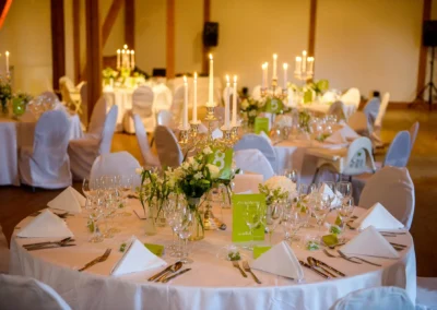Elegante Tischdekoration bei einer Hochzeit auf Gut Georgenberg, mit Kerzenleuchtern und Blumenschmuck. Hochzeitsfotografie.