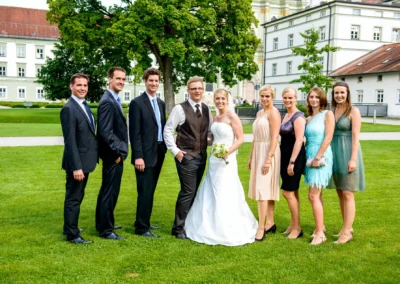 Brautpaar mit Freunden im Garten einer Hochzeitsfeier in Kloster Fuerstenfeld nahe Muenchen. Hochzeitsfoto in Oberbayern.