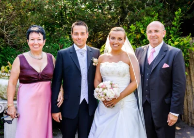 Brautpaar mit Eltern in festlicher Kleidung bei einer Hochzeit in der Alten Gaertnerei Taufkirchen, Hochzeitsfoto.