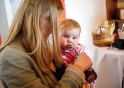 Mutter mit Baby auf Hochzeit in Oberbayern. Hochzeitsfotografie Momente bei Hechenberg.