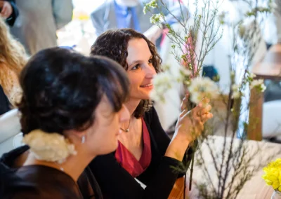 Gaste geniessen eine Hochzeit, halten Blumen in Hechenberg. Hochzeitsfotografie faengt glueckliche Momente ein.