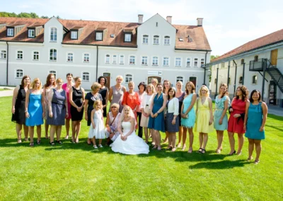 Gruppe von Frauen mit Braut bei Hochzeitsfoto vor historischem Gebaeude in Kloster Fuerstenfeld, nahe Muenchen.